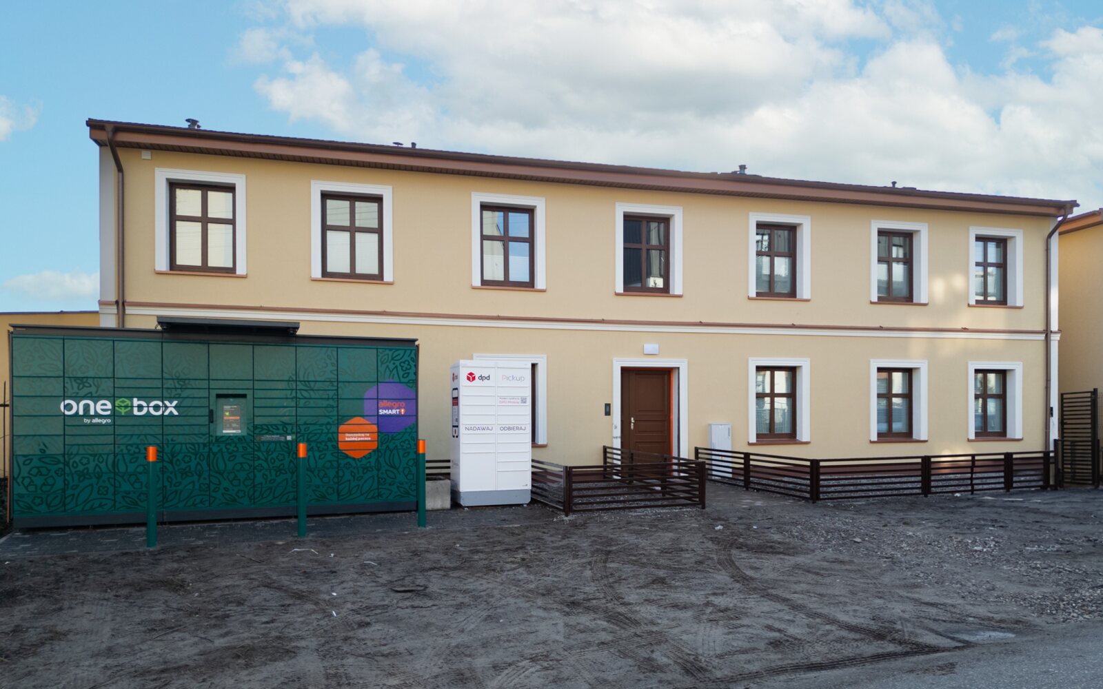 Niskie ogrodzenie frontowe z poziomych lameli przy odnowionym budynku mieszkalnym